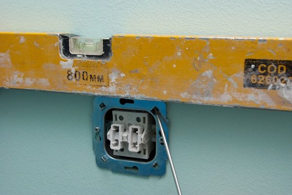 После погружения механизма выключателя в гнездо, выравнивают положение по уровню